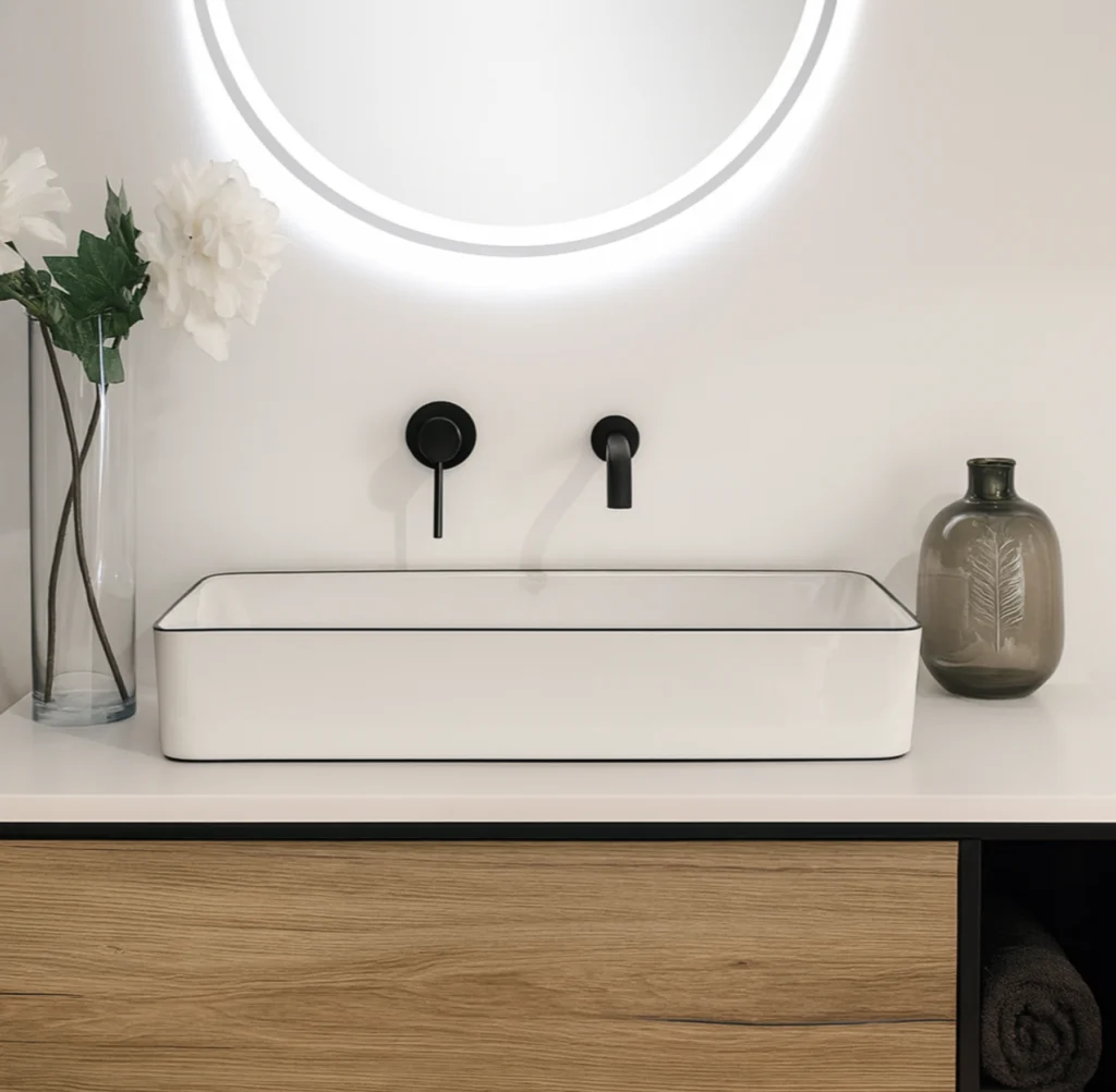 Lavabo sobre encimera rectangular en cerámica blanca con borde negro